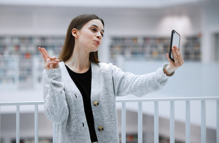 Selfie, library and woman with peace sign for social media, influencer blog post or studying update...