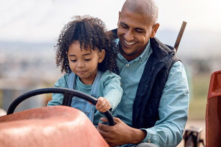 Agriculture, father and daughter on tractor, love and bonding together, outdoor and happiness. Family, dad and girl on farming vehicle, playful or child development on break, smile or loving on breakの写真素材