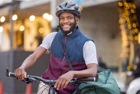 Black man, bicycle and portrait smile in the city for travel, trip or delivery with bag outdoors. Happy African American male on bike smiling for traveling, adventure or transport in an urban townの写真素材
