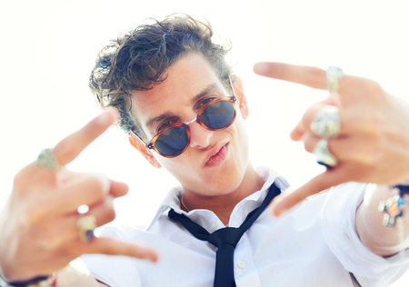 Working hard to be cool. Low angle portrait of a stylish young man making hand gestures at the...
