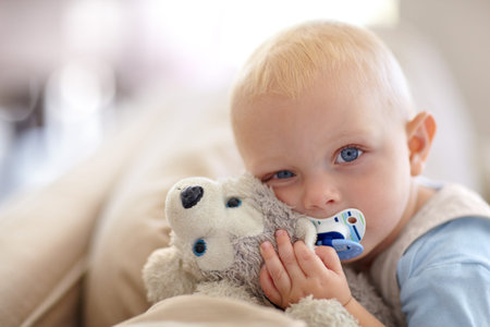 Getting ready for bed. Portrait of a cute baby boy holding a stuffed animal while looking at the...