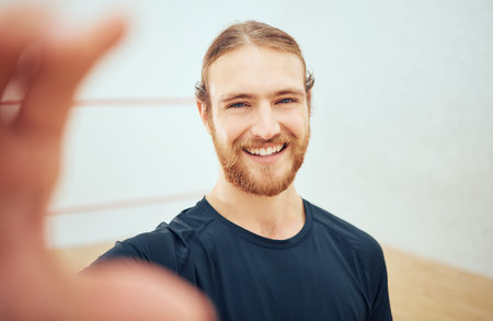 Portrait of young athletic squash player taking selfie after playing court game with copyspace....