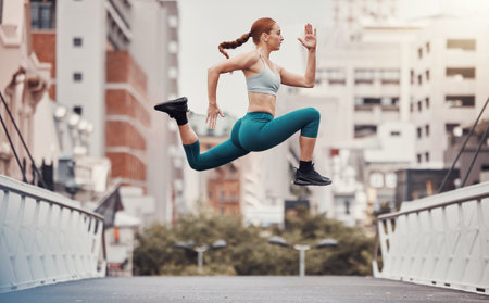 Workout, jump and health with woman in city for training, cardio and endurance. Energy, fitness and exercise with girl athlete and warm up in urban town for sports, running and body wellnessの写真素材