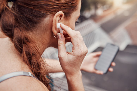 Fitness, phone or woman with music in city to start training, workout or running exercise in Miami. Headphones, motivation or healthy sports girl athlete streaming radio or podcast about mindsetの写真素材