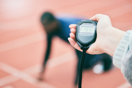 Sports, running and hands with stop watch on race track for exercise, marathon training and fitness....