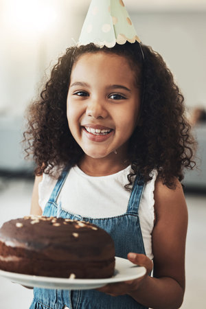 Portrait of happy girl with birthday cake, child in home and surprise celebration in Atlanta house...