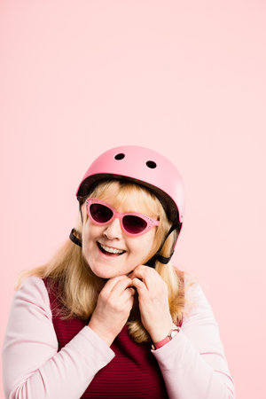 Lets go. a mature woman standing alone in the studio while wearing sunglasses and a helmet.の写真素材