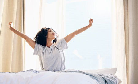 Black woman, morning stretching and wake up in home bedroom after sleeping or resting. Relax, peace...