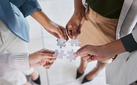 Top view, puzzle and hands with business, partnership or planning for new project, teamwork or staff. Team, group or jigsaw with collaboration for innovation, career success or brainstorming togetherの写真素材