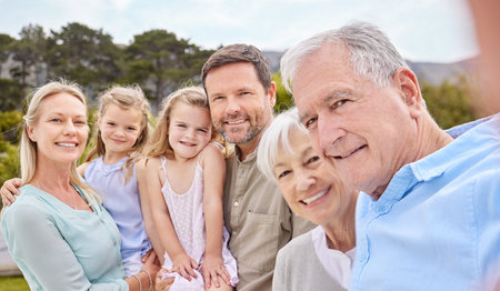 Being part of a family means smiling for photos. a family taking a selfie in a park.