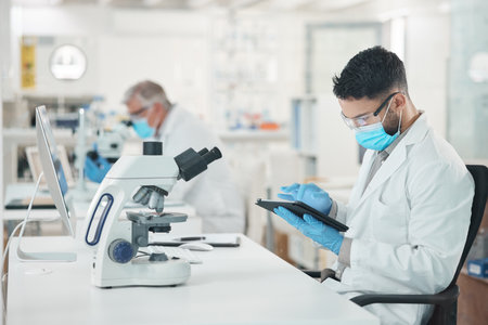 My work will contribute to an amazing body of research. a young scientist using a digital tablet while working in a lab.の写真素材
