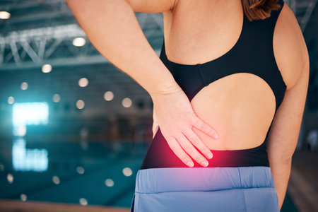 Spine pain, swimmer and woman by a pool with injury from exercise, workout and swim race. Back...
