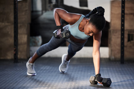 Make your body stronger. a fit young woman working out with dumbbells at the gym.