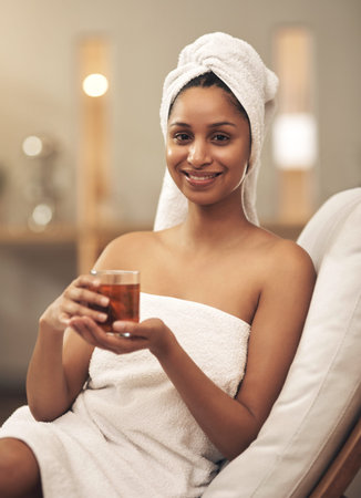 Who doesnt love a spa day. a woman drinking tea while enjoying a spa day.