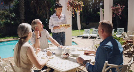 Whos ready to eat some yummy food. a group of family members having lunch outside.