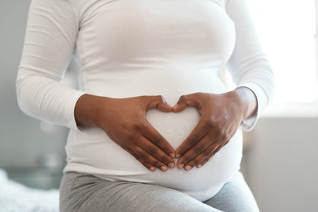 Loving the journey of motherhood. Closeup shot of an unrecognisable woman making a heart shape with...