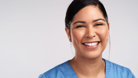 Doctors, the Gods of earth. Portrait of a young beautiful doctor in scrubs against a white...