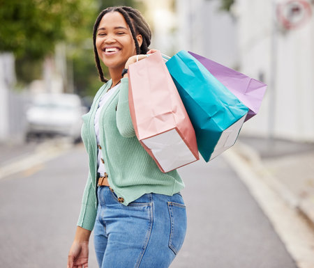 Fashion, portrait or happy black woman with shopping bag or smile walking on city street after...