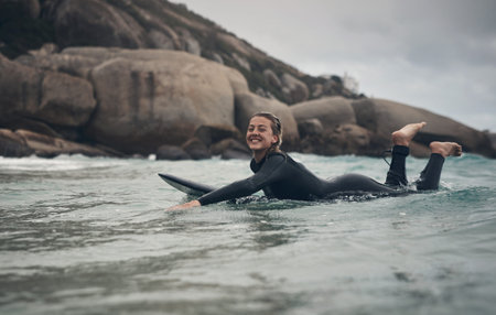 Nothing can match the adrenaline kick of catching a great wave. a young woman out surfing at the...