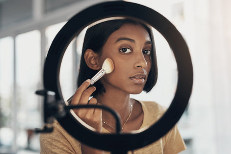 Time to stop hiding your beauty and start highlighting it. a young woman applying makeup while...