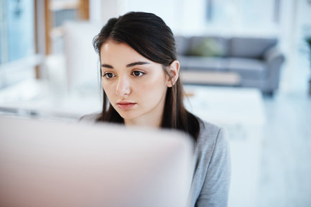 Dont wait for it, work for it. a young businesswoman using a computer in a modern office.の写真素材