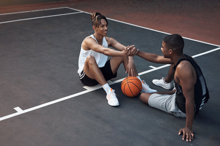 Its always good playing with you, dude. two sporty young men shaking hands on a basketball court.の写真素材