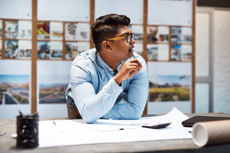 Designing the kind of buildings you see in your dreams. a young architect designing a building plan...