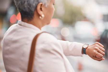 Watch, senior woman and check time for appointment, deadline and schedule while travelling. Female employee, manager and mature lady with wrist watch, outdoor and commute to work, late and waitingの写真素材