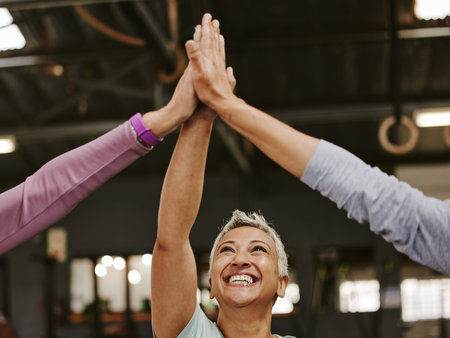 Fitness, teamwork and high five of senior women in gym celebrating workout goals. Sports targets,...