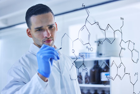 Genetic coding at its finest. a handsome young male scientist working on a glass wipe board in his lab.の写真素材