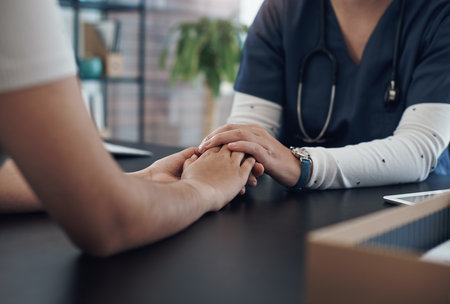 We all need a hand to hold sometimes. an unrecognizable doctor holding hands with a patient in an office.の写真素材