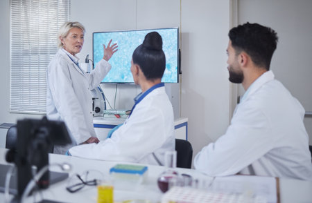 Science, presentation and woman scientist in the laboratory meeting, training or seminar. Innovation, leadership and senior female speaker presenting research discovery to team with technology in labの写真素材