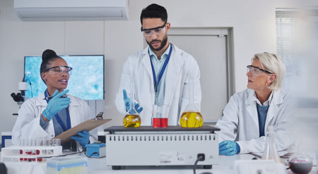 Science, laboratory and team with chemistry liquid in glass beaker for medical research, study and...