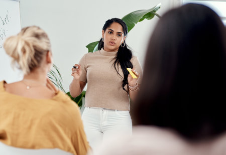 We are always learning and growing. an attractive young businesswoman standing and giving a presentation to her colleagues in the office.の写真素材