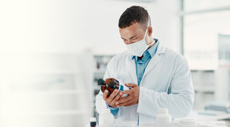 Consistent research leads to consistent success. a young scientist analysing medication in a...