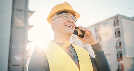 Architecture, construction and old man on a phone call in city for network, industrial and building. Engineering, communication and builder talking, planning and conversation for property developmentの写真素材