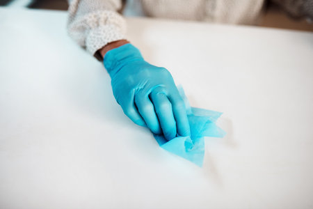 Routine cleaning is key. Closeup shot of an unrecognisable businesswoman cleaning her workspace in an office.の写真素材