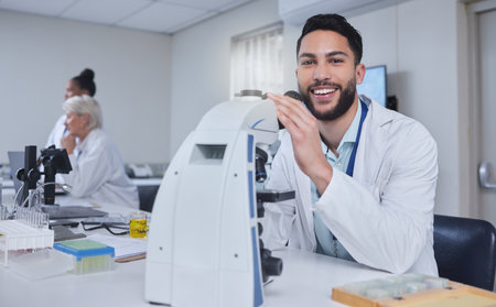 Man, microscope and portrait of scientist in laboratory for research, experiment or innovation. Science, technology or smile of happy male doctor with medical equipment for sample analysis or testingの写真素材