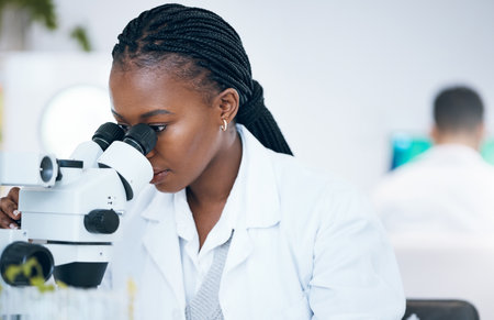 Medical science, black woman and microscope in laboratory for research, analytics and medicine. Woman, doctor and scientist study at work for an investigation, healthcare and futuristic mock up spaceの写真素材