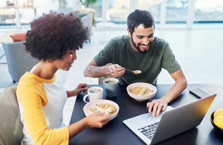 We always start the day with some motivational videos. a young couple using a laptop while having...