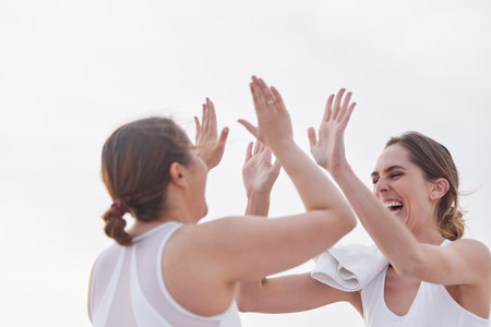 Exercise, women and high five for celebration, workout goal and fitness outdoor, support and achievement. Females, athlete and girl with gesture for victory, winning and happiness for target or smileの写真素材