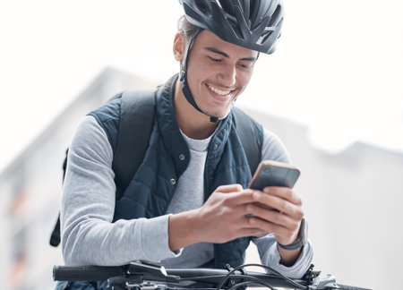 Delivery, bike travel or man with phone in city, street or road for GPS, location or networking outdoor. Smile, helmet or male with smartphone app for communication, social media or 5g networkの写真素材