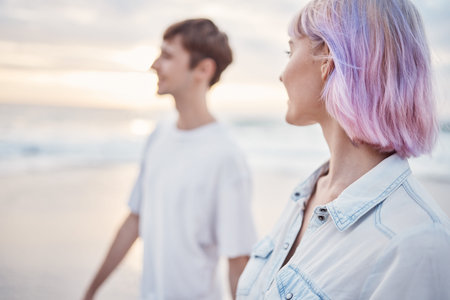 Gen z couple, beach walk and sea holiday of students on vacation at sunset. Ocean, walking and relax...