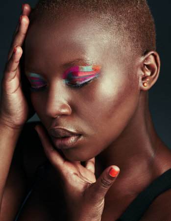 Let them see you in color. a beautiful woman wearing colorful eyeshadow while posing against a grey...