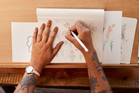 My client has various designs to choose from. a young woman sketching at home.の写真素材