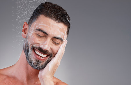 Mockup, man and water for face, beauty and foam for washing, dermatology and grey studio background. Skincare, male and gentleman cleaning, cosmetics and morning routine for treatment and soft skinの写真素材