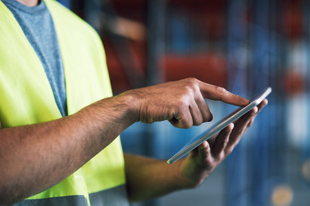 Save time, conduct inspections online. a builder using a digital tablet while working at a...