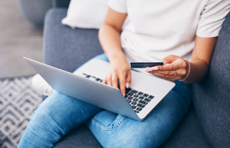 Online shopping, laptop or hands with credit card for financial digital payment while relaxing on sofa at home. Zoom, finance or girl typing ecommerce subscription discount code, sales offer or dealの写真素材