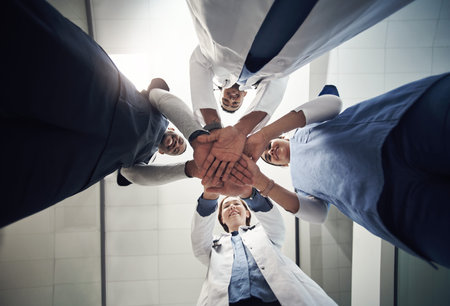 I believe in you. a group of young doctors and n nurses with their hands stacked.