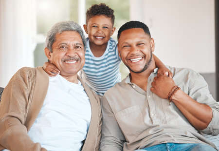 Raising a prince. Portrait of a mature man sitting with his son and holding his grandson at home.の写真素材